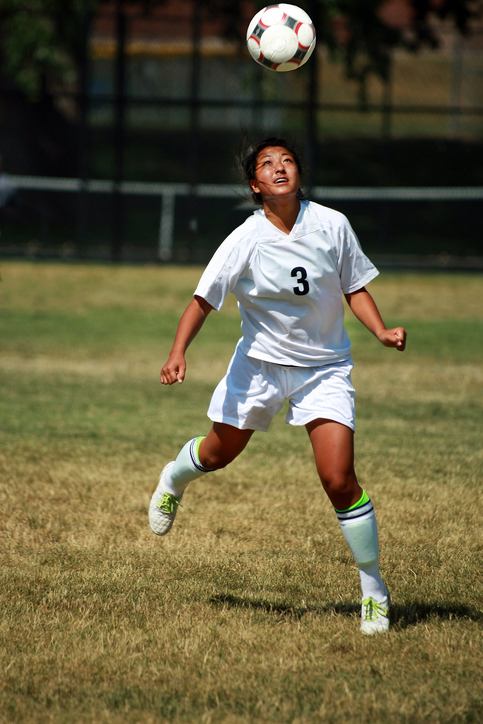 Soccer player performing a header, this is a subconcussive head injury.